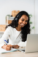 Insurance company worker talking on headset. Indian entrepreneur working from home in front of...