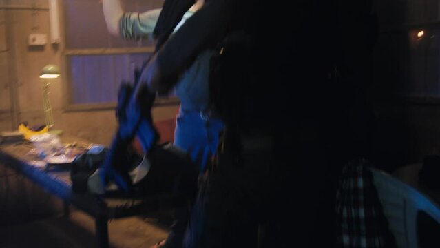 Police arresting man in dark room