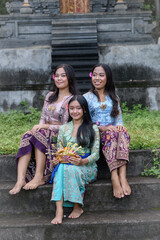 Balinese cultural tradition of offering making with young women in colorful outfits.