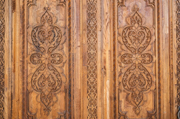 traditional oriental Uzbek Islamic patterns arabesque ornament on an old wooden carved door in Uzbekistan close-up