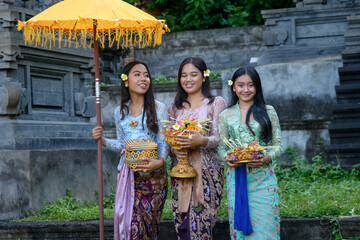 Traditional Balinese ceremony with smiling women wearing ethnic clothes