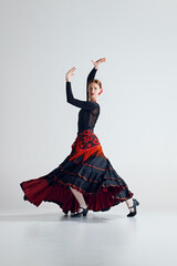 Flamenco female dancer in full motion performing with grace and intensity, highlighting dynamic...