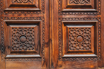 Oriental tajik Islamic kandakori patterns arabesque ornament on an old wooden carved door in Tajikistan close-up