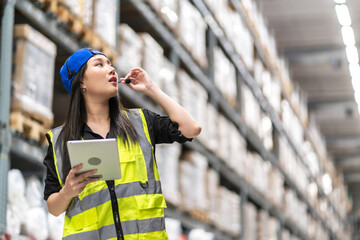 Female engineer is handling shipping and checking stock inventory in the warehouse with a tablet,...