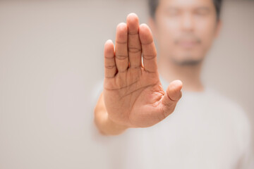 White shirt man showing stop gesture isolated on gray background.Closeup hand of a business man showing stop, saying no or not accepting a deal in an office at work. - obrazy, fototapety, plakaty