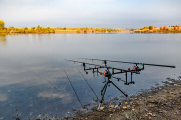 Carpfishing session at the Lake.Carp fishing rods standing on special tripods.Scenic landscape...
