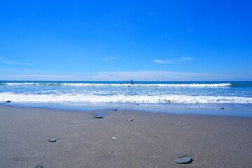 きらきら輝く夏の海で、サーファーがサーフィンを楽しむ夏のイメージ
