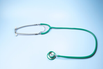 A green stethoscope is on a blue background