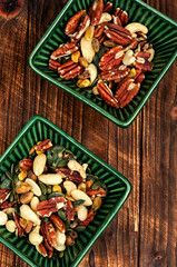Mixed nuts in a bowl on wooden background.
