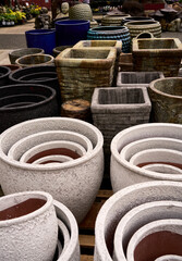 A variety of different colorful plant pots for sale at a garden center.