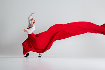 Stunning moment captures t essence of flamenco. Female dancer in red costume red in dramatic...