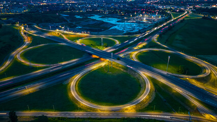 Road and Roundabout, multilevel junction motorway at night. Expressway top view. A51 Tangenziale...