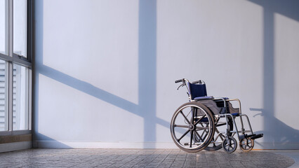 Empty Wheelchair on cobblestone tile floor with sunlight and shadow on gray interior wall surface