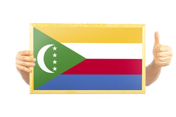 Hands holding a frame with Comoros flag, two hands and thumb up, independence day idea, celebration