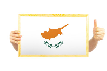 Hands holding a frame with Cyprus flag, two hands and thumb up, celebration or victory concept