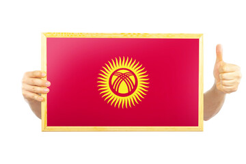 Hands holding a frame with Kyrgyzstan flag, independence day idea, celebration or victory concept
