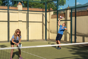 Middle-Aged Man Performing High Padel Serve
