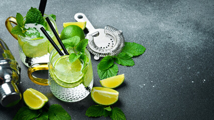 A glass of Traditional mojito cocktail with mint and lime. On a dark stone table.