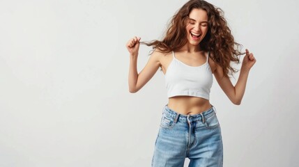 A woman with curly hair is smiling and holding her hair back