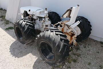 Small vintage tractor with wide tires, painted white, used for transportation in salt production...