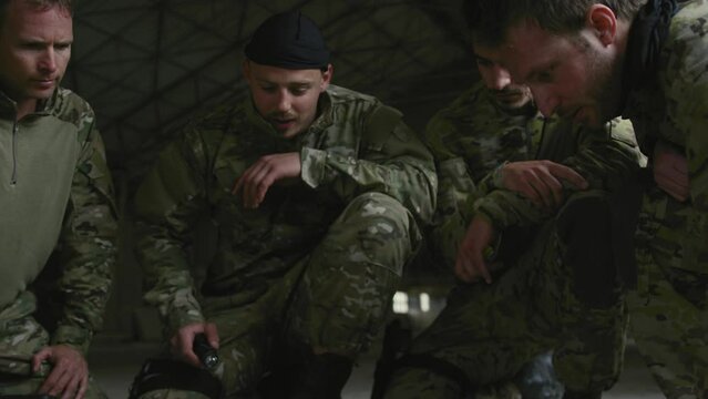 Soldiers kneeling around map on floor indoors