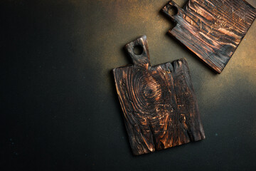 Kitchen board and kitchen wooden utensils on the kitchen table. On a dark background. Top view....