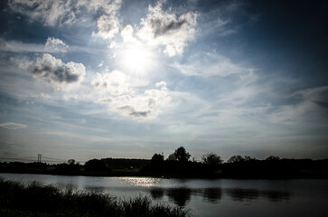 Fototapeta premium Dramatic sky with clouds over the river. Nature composition.