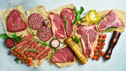 Assortment of meat and meat products. Steak, ribeye steak, kebab and burger patty. On a gray stone...