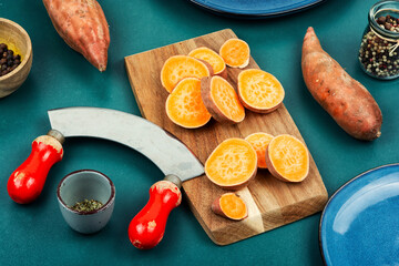 Sliced sweet potato or yam on cutting board.