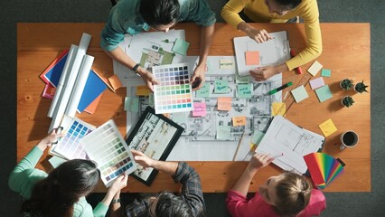 Top down aerial view of interior designer team choosing color from palettes while architect...