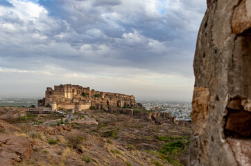 Fototapeta na wymiar ancient historical fort with colored city houses and dramatic cloudy sky at evening