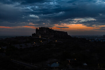 backlit shot of ancient historical fort with dramatic sunset sky at dusk from flat angle