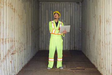worker or engineer working on laptop computer and checking inside containers warehouse storage