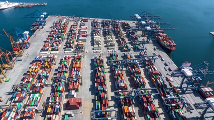 Aerial hyper lapse view of a industrial cargo container terminal with loading and unloading activity