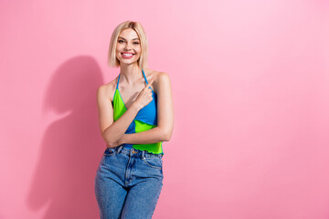 Photo of lovely cheerful girl with bob hairdo dressed colorful tank indicating at offer empty space...