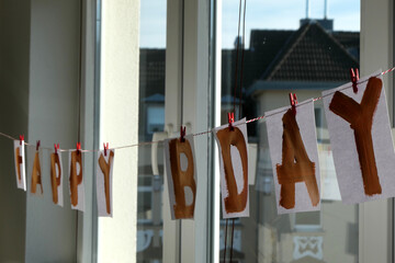Self-made birthday garland hung in front of a window
