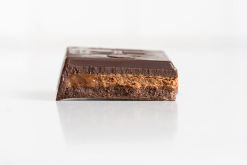 darrk chocolate with hazelnut butter filling on white background, shown in cross section, close up macro with copy space