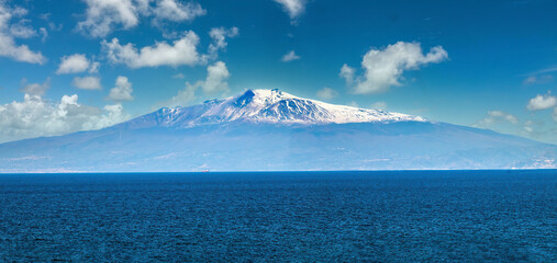 Navigating in front of the iconic Mount Etna (Mongibello), an active streto volcano between the...
