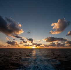 Spectacular sunset over the waters of the strait of Messina between the island of Sicily and...