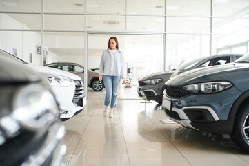 Happy woman customer female buyer client choose auto want to buy new automobile in car showroom