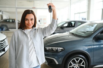 Beautiful young female client customer choosing new car