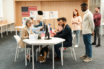 Multinational group of divers US citizens, voters registering at polling station with American flags
