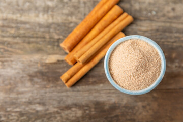 Cinnamon sugar on a texture background. Homemade cinnamon sugar in a bowl on background. Brown sugar. Spice mixture for drinks and baking. Place for text. Copy space.