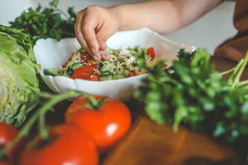 Preparing vegetable salad, sprinkle flax and sesame seeds