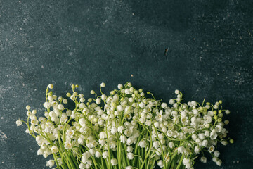 Lilies of the valley on a black background, a place for congratulations