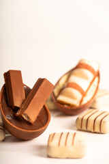 Chocolate eggs, small chocolate eggs details, white background, selective focus.