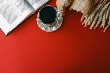 Bread and wine, communion concept on red background, top view