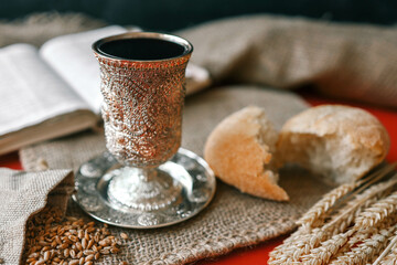 Cup with wine, bread and open Bible, Christian communion