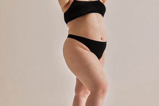 Beauty and uniqueness of natural body shapes. Cropped image of oversized feme body in nerdwear against grey studio background. Concept of natural beauty, body positivity, care, acceptance