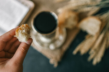 Cup with wine, bread and open Bible, Christian communion